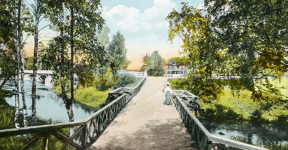1900-luvun taitteessa tuotettu postikorttikuva Ilosaaren sillalta kohti Niskasaarta. Sillan alitse virtaa leveänä Kaluvirta. Taustalla näkyy Niskasaaressa sijainnut paviljonki-huvimaja. Kuva on painattajan jälkivärittämä ja sitä on digitaalisesti paranneltu vuonna 2024.