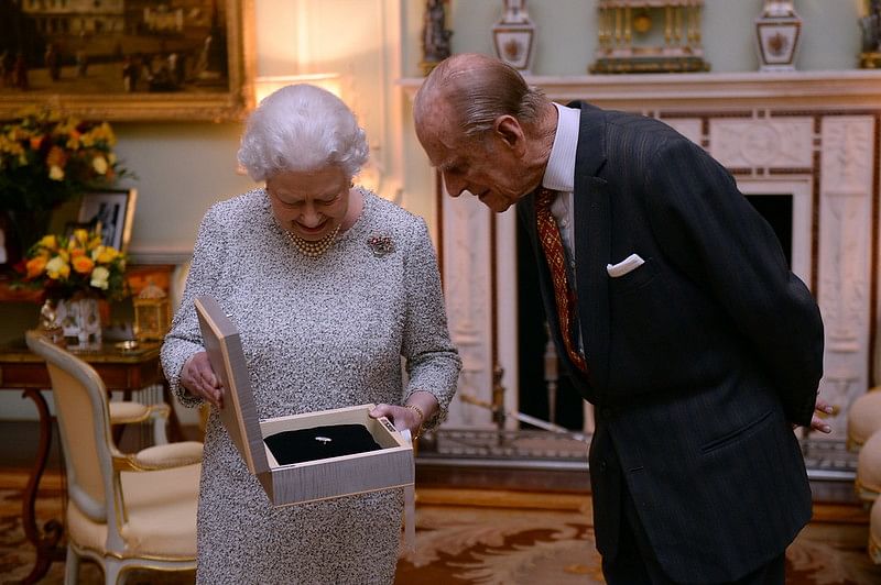 Kuningatar Elisabet ja hänen puolisonsa prinssi Philip tutustuvat Kansainvälisen Ratsastajainliiton myöntämään huomionosoitukseen elinikäisestä omistautumisesta hevosurheilulle.