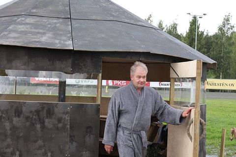Saunashamaani Tarvainen seuraa Kuninkuusraveja Hevosurheilun saunasta, josta on näköala koko radalle.