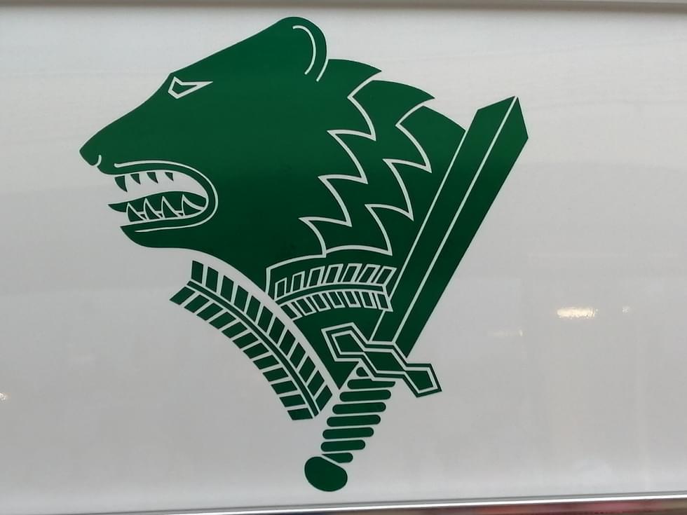 Rajavartiolaitoksen tunnuksessa on karhunpää miekkoineen.