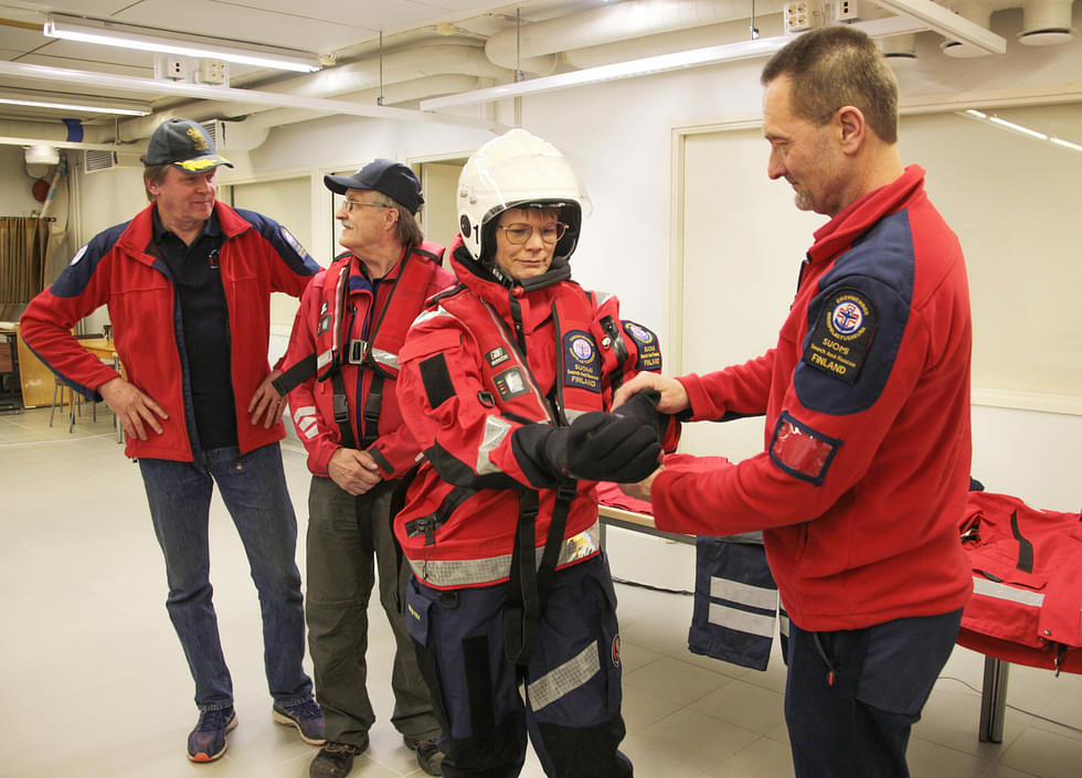 Jari Korhonen (oik.) avusti Heidi Vornasta pelastuspuvun pukemisessa. Alusvastaava Hannu Kortelainen ja Erkki Mustonen kokeilivat muita varusteita.