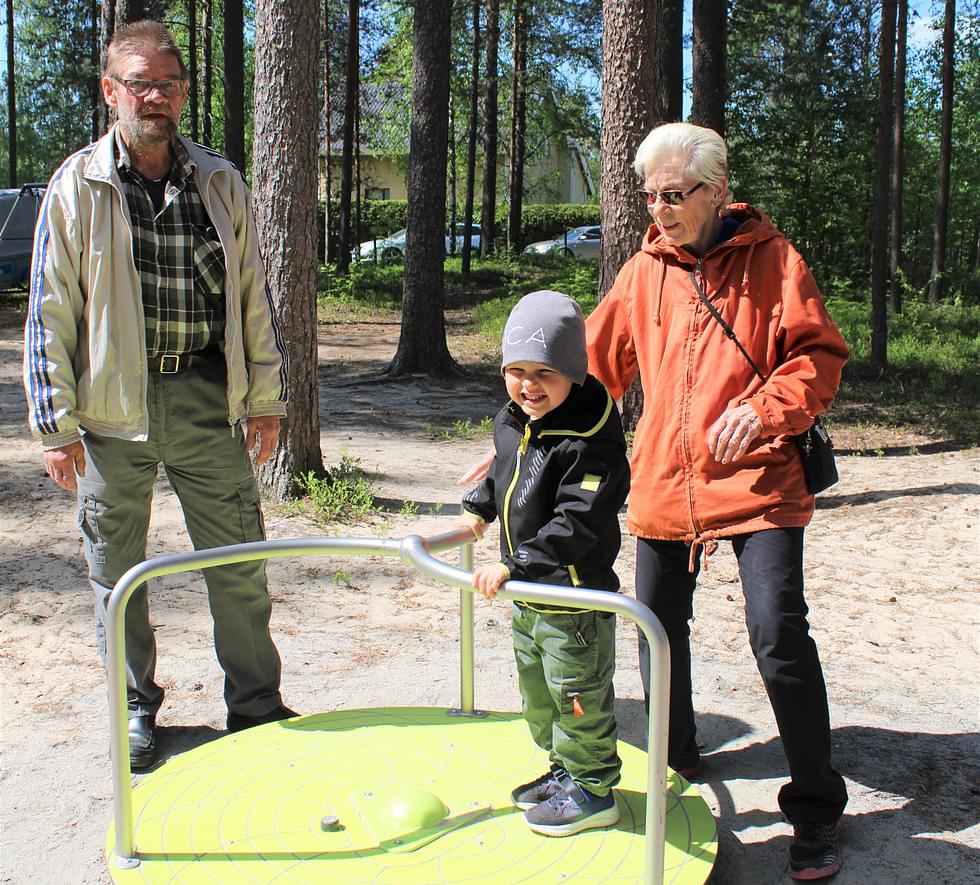 Peruspankakoskinen Matti Partanen on viihtynyt liki 70 vuotta takana näkyvässä synnyinkodissaan. Leikkikentän avajaisissa hän kokeili karusellia tyttärenpoika Luca Litmasen ja puolisonsa Anja Kivelän kanssa.