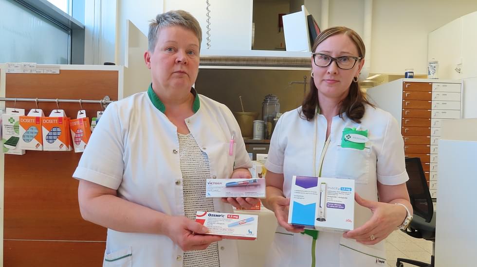 Virpi Heikkinen (vas.) ja Kaisa Jääskeläinen esittelevät laihduslääkkeinä tunnettuja valmisteita, joiden saatavuudessa on ollut ongelmia.
