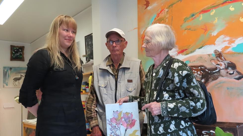 Tuuli Meriläinen (vas.) kertoi Ilmari  ja Liisa Tuhkaselle heidän ostamastaan kukka-aiheisesta teoksesta.