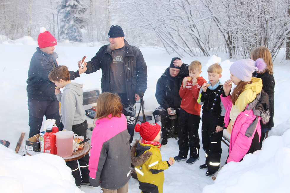 Evästä riittää kaikille nuorisobussin kävijöille. Tero Kiiskinen tarjoilee makkaraa Timo Nuutiselle ja lapsille maistuu keksit ja mehu  askartelun lomassa.