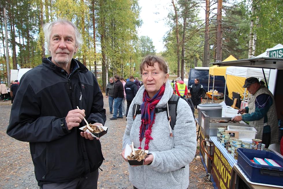 Urpo ja Liisa Ehrukainen nauttivat Matti Surakalta (oik.) ostamistaan muikuista Vuonislahden muikkumarkkoilla lauantaina.