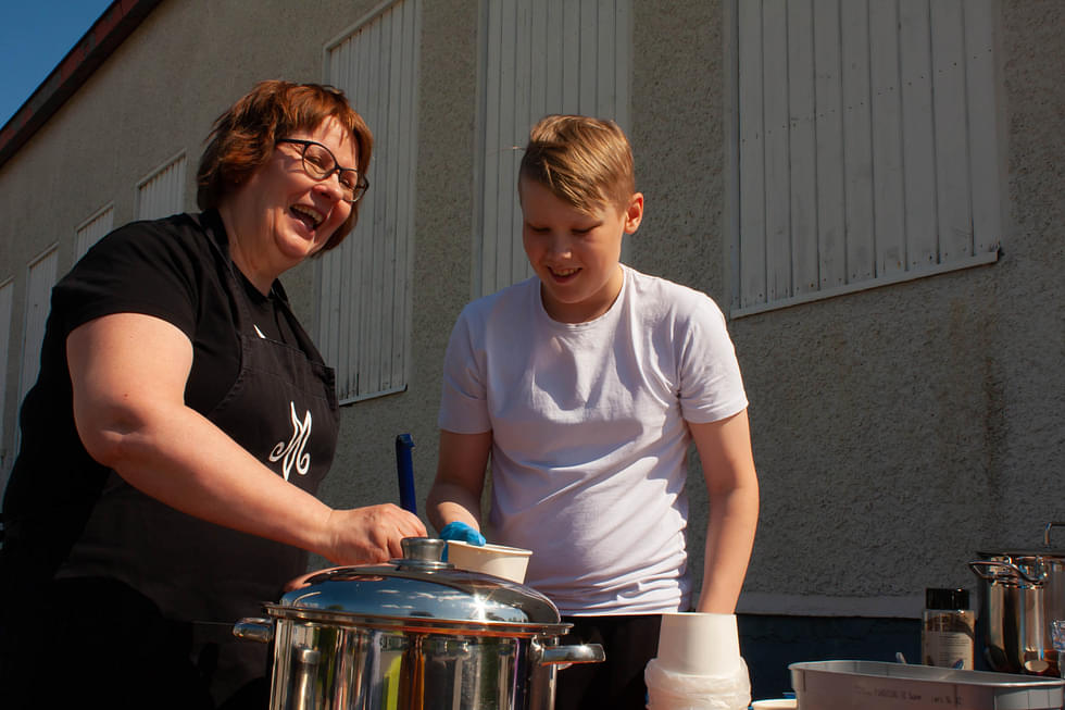 Marttojen Tiina Anola-Pukkila ja 7-luokkalainen Juuso Eronen olivat innoissaan jakamassa nakkikeittoa 4H-yhdistyksen pihalla.