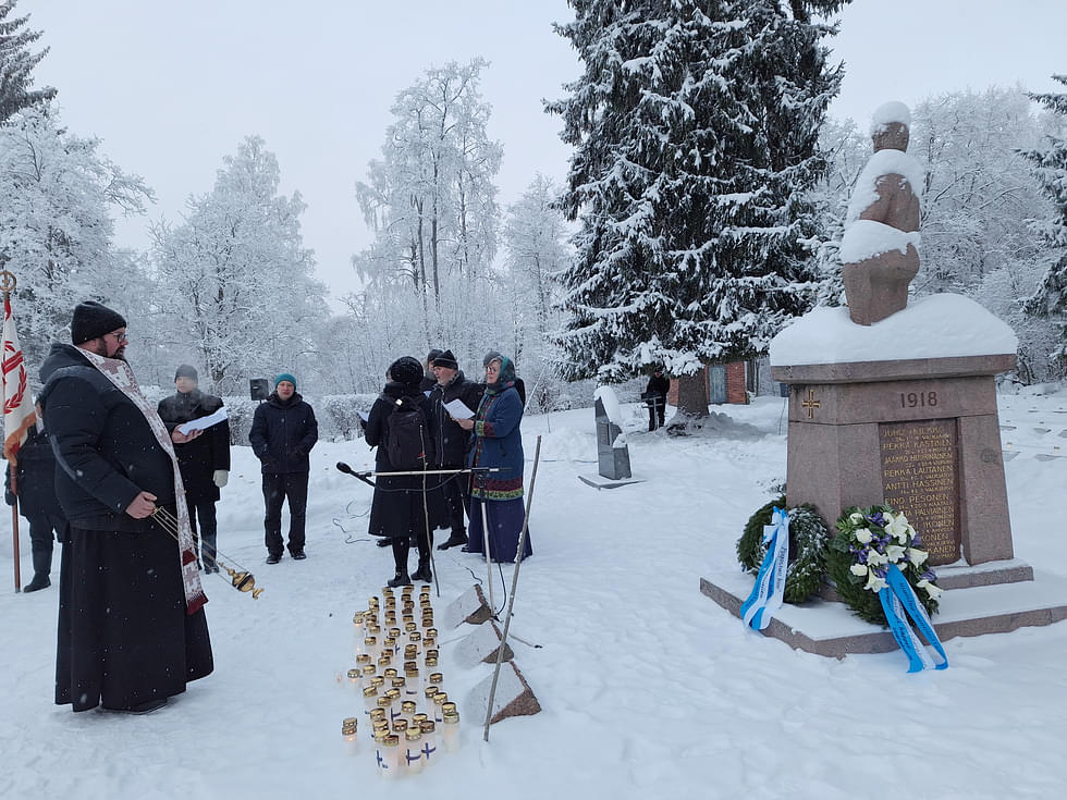 Pastori Jaso Pössi piti litanian sankarivainajien muistolle. Kynttiläjoukko on koululaisten aiemmin tuoma. 