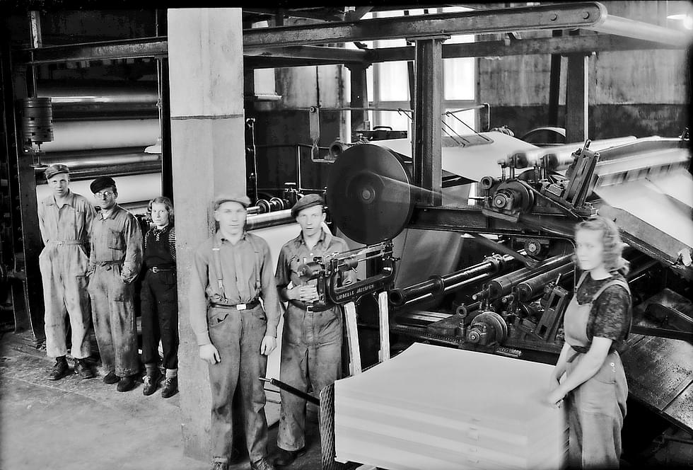 Tehtaan työntekijöitä kartonkikoneella. Kuva 1940-luvulta.