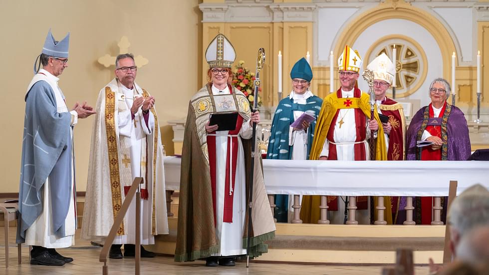 Mari Parkkinen sai piispan viran tunnukset eli piispanristin ja -sauvan sekä piispankaavun ja -hiipan.