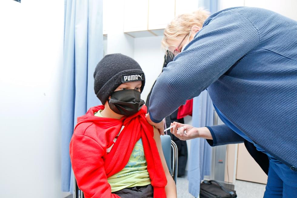 Kuvassa terveydenhoitaja Merja Leppänen pistää ensimmäistä koronarokotetta Aapo Pulkkiselle tammikuussa 2022.