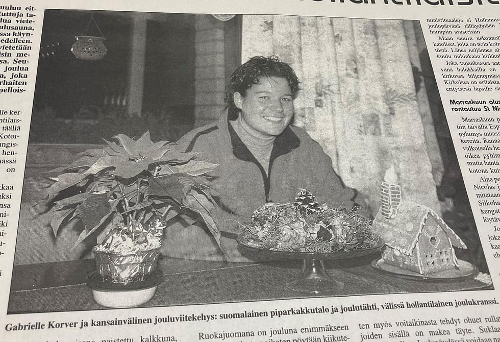 Gabrielle Korver ja kansainvälinen jouluviitekehys: suomalainen piparkakkutalo ja joulutähti, välissä hollantilainen joulukranssi.