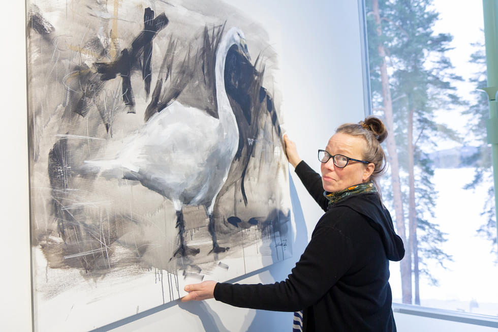 Suvi Komsa ripusti maalauksiaan Galleria Tykon näyttelytilaan maanantaina. Näyttely on esillä Nurmes-talon Galleria Tykossa 31. tammikuuta saakka.