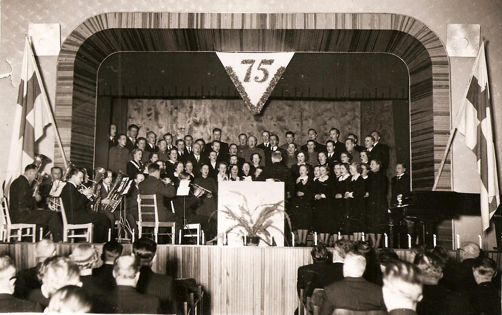 Nurmeksen Kauppalan 75-vuotisjuhla järjestettiin Keskustan koululla joulukuussa 1951. Kuvassa musiikkiyhdistyksen sekakuoro esiintyy torvien säestyksellä. 