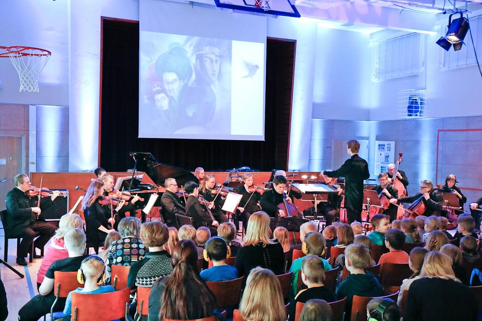 Musiikkisatu Lintu sininen kasvaa monitaiteelliseksi näyttämöteokseksi. Kuva Lintu sininen koululaiskonsertista Porokylän koululla vuonna 2020.