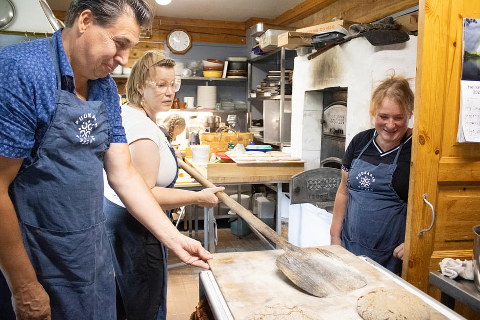 Puukarin Pysäkillä hyvin nukutun yön jälkeen tamperelaiset Pekka ja Kati Lehtinen opettelivat ruisleivän tekoa emäntä Anni Korhosen (keskellä) opastuksella.