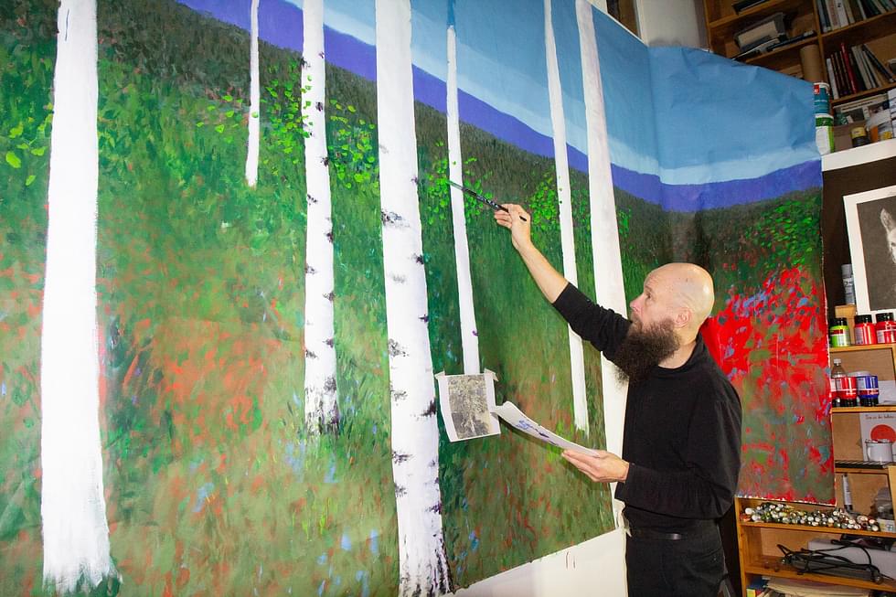 Anssi Okkonen on maalannut lavastekangasta työhuoneellaan Kuokanvaarassa.