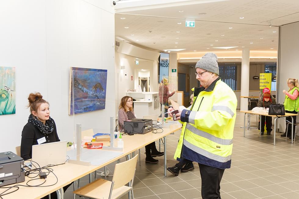 Pekka Kuittinen oli Nurmes-talolla ensimmäinen äänestäjä keskiviikkona. Kuvassa on vaalitoimitsija Niina Taurovaara.