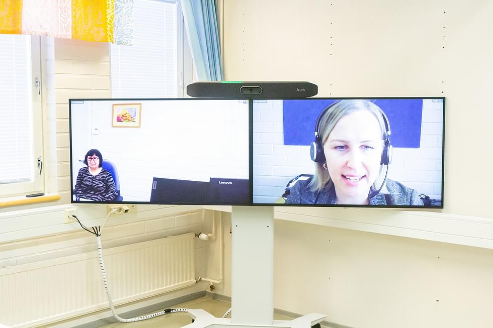 Johtava julkinen oikeusavustaja Anu Silvennoinen  näyttää, miten videoyhteys Joensuusta Nurmekseen toimii. 
