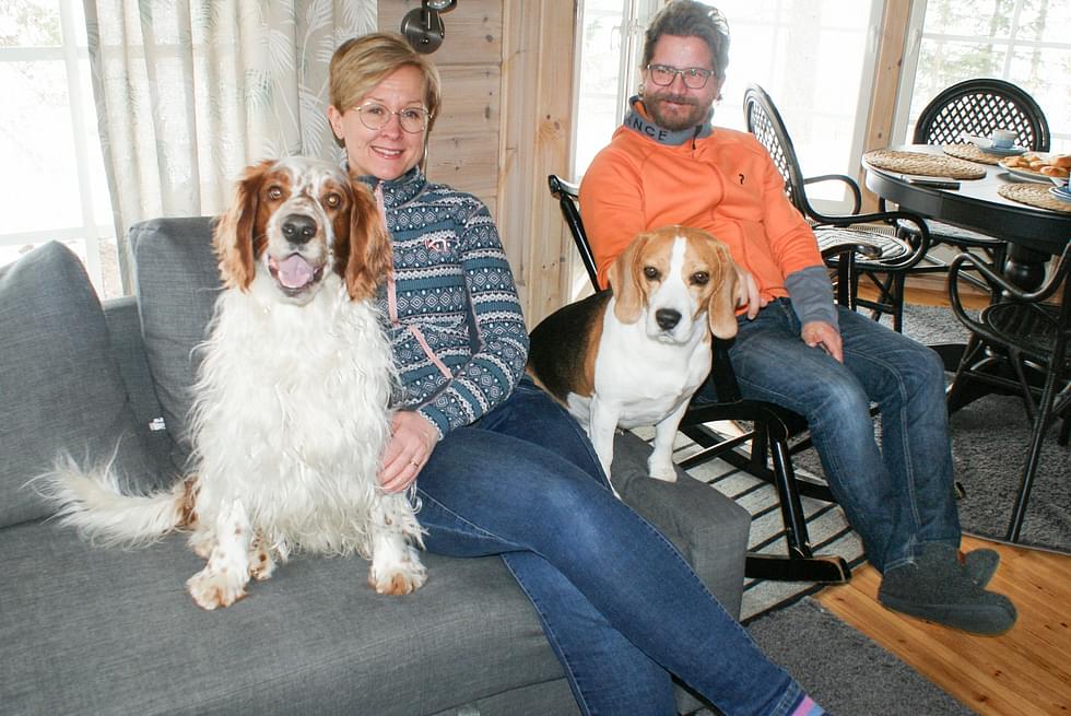 Koko perhe koossa. Johanna Nevalaisen vasemmalla puolella oleva koira on Vihtori ja Johanna ja Mika Nevalaisen välissä istuu Jeppe.