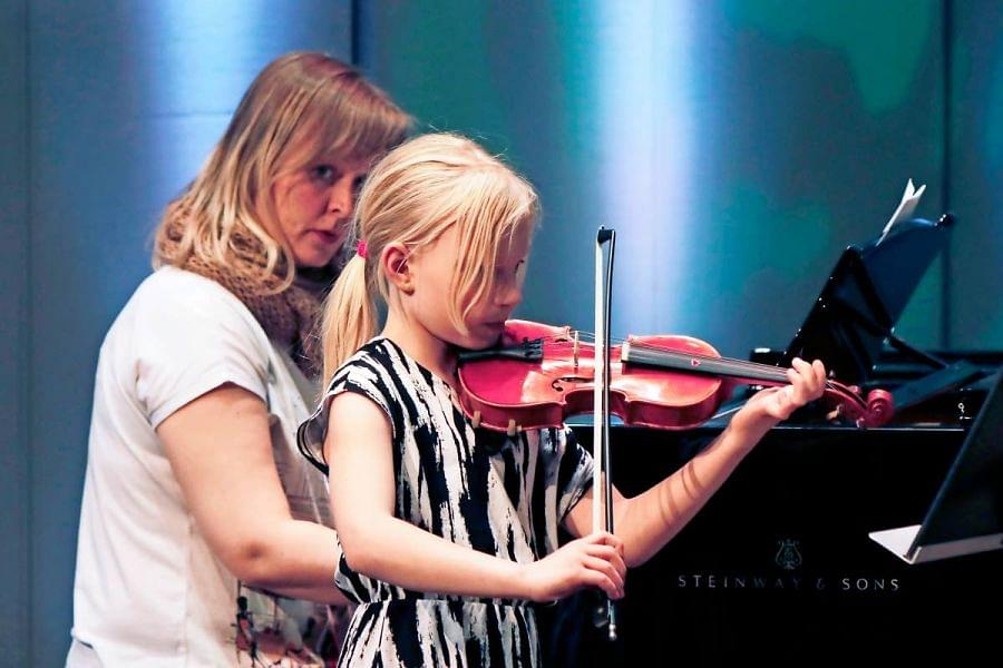 Pielisen Karjalan musiikkiopiston oppilaskonsertti nähdään ja kuullaan keskiviikkona Hannikaisen salissa. Kuva vuoden 2022 kesän oppilaskonsertista. Kuvassa Henni Reis soittaa viulua, säestäjänä toimii Marja Kalevi.